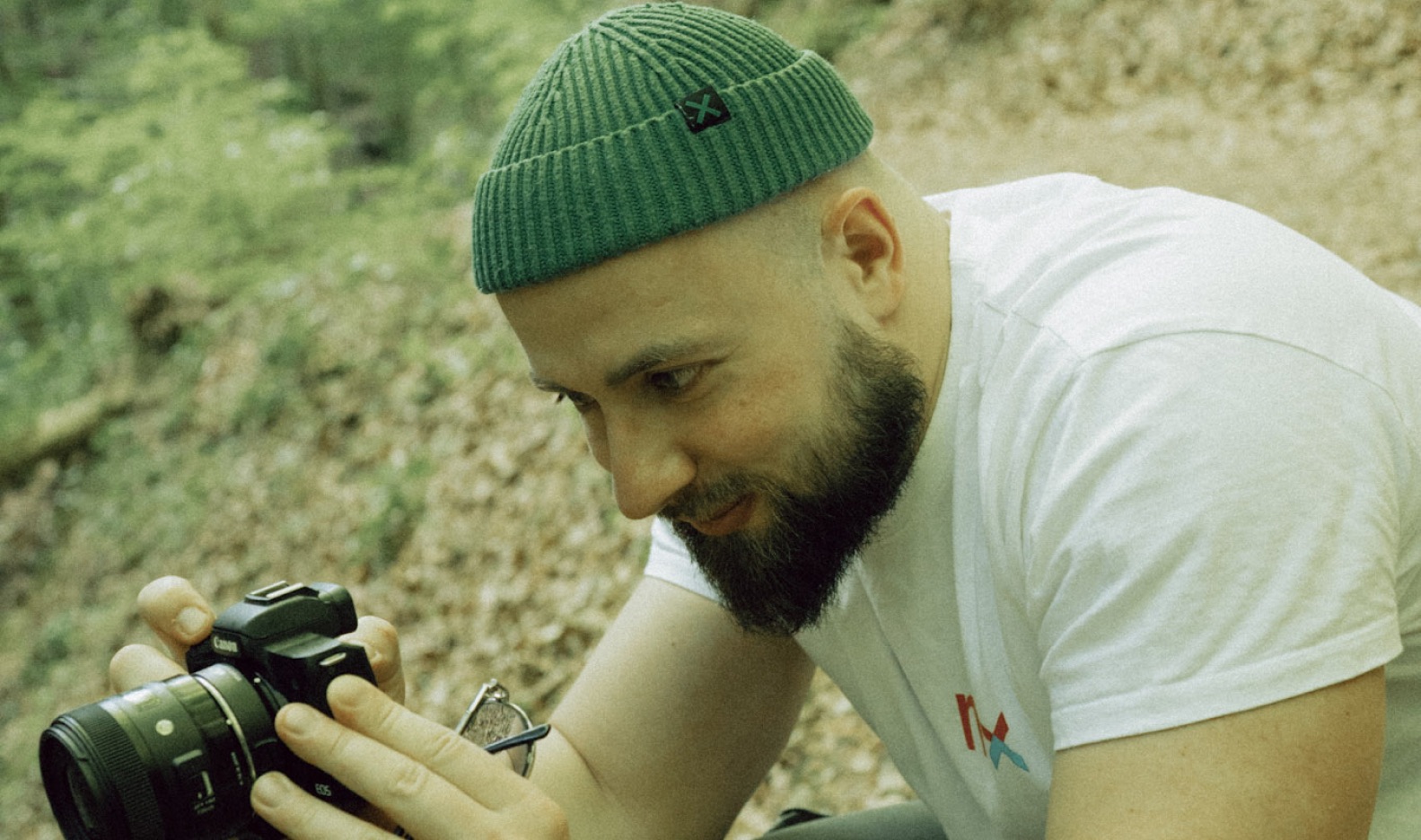 Max checking a shot on his camera on a forest trail