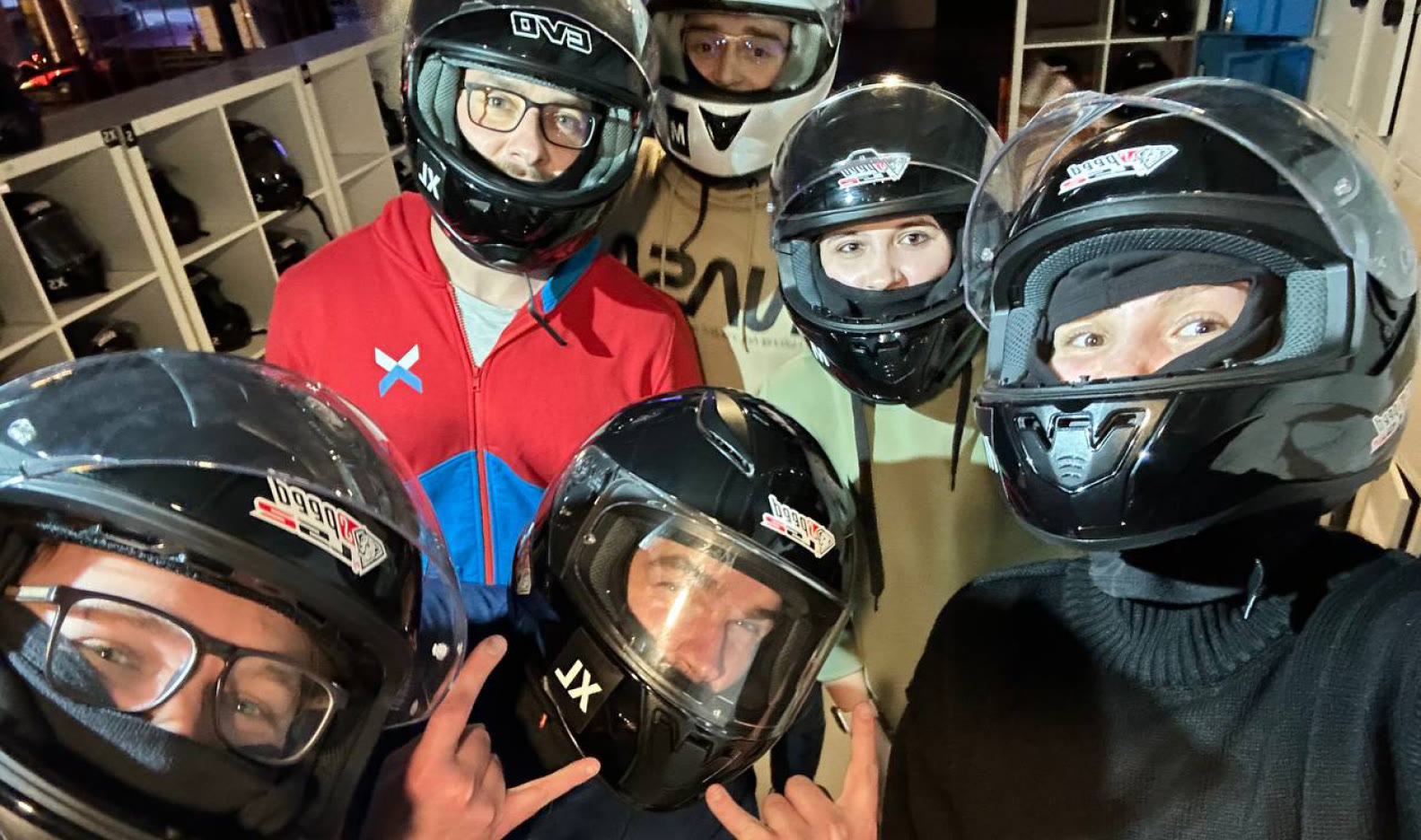 The same team crowded into the frame in racing helmets, before going out on track